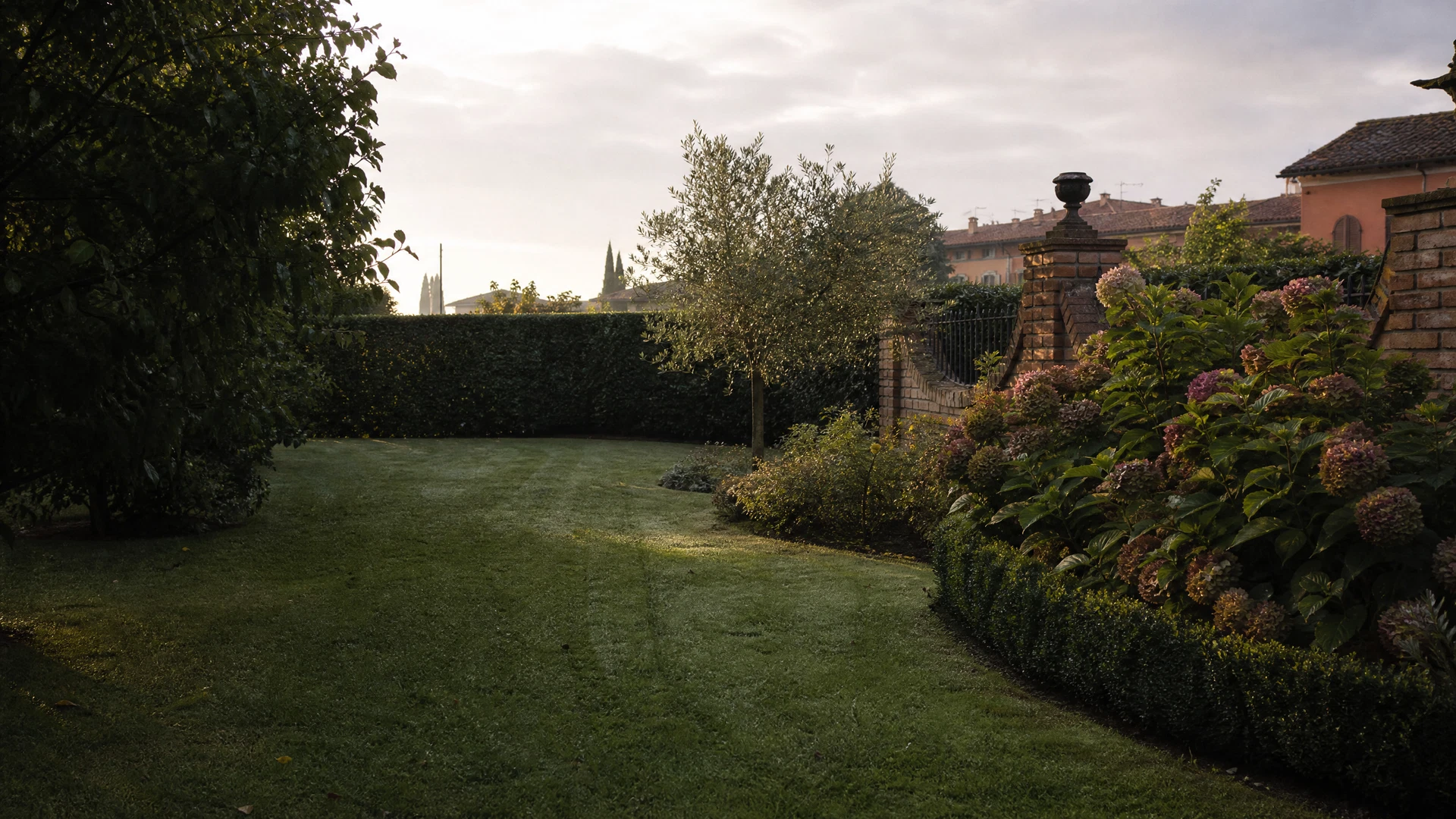 Giardino privato curato con prato tagliato e siepe ordinata, immagine d’atmosfera
